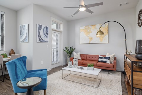 A living room with a blue chair and a red couch.